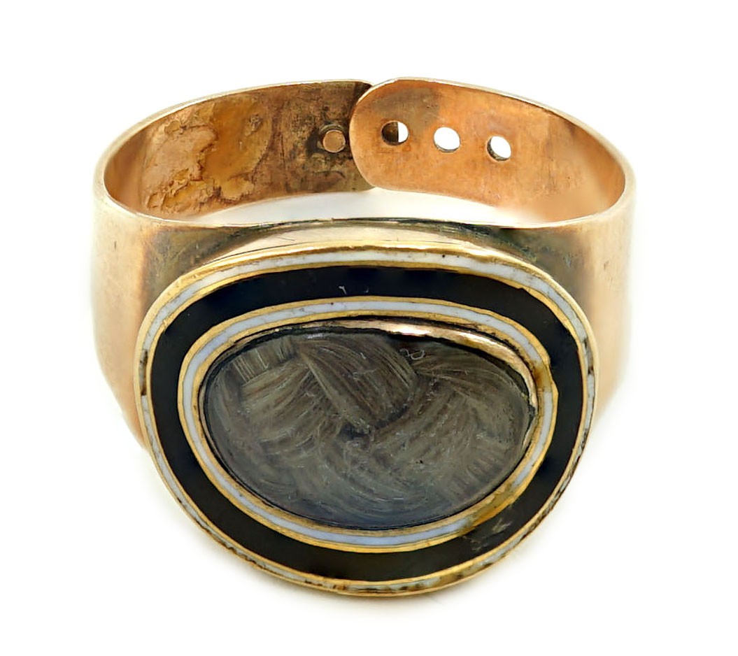 A George III gold and two colour enamel mourning ring, with adjustable 'buckle' shank